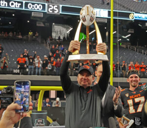 Oregon State head coach Jonathan Smtih holding up Las Vegas Bowl trophy