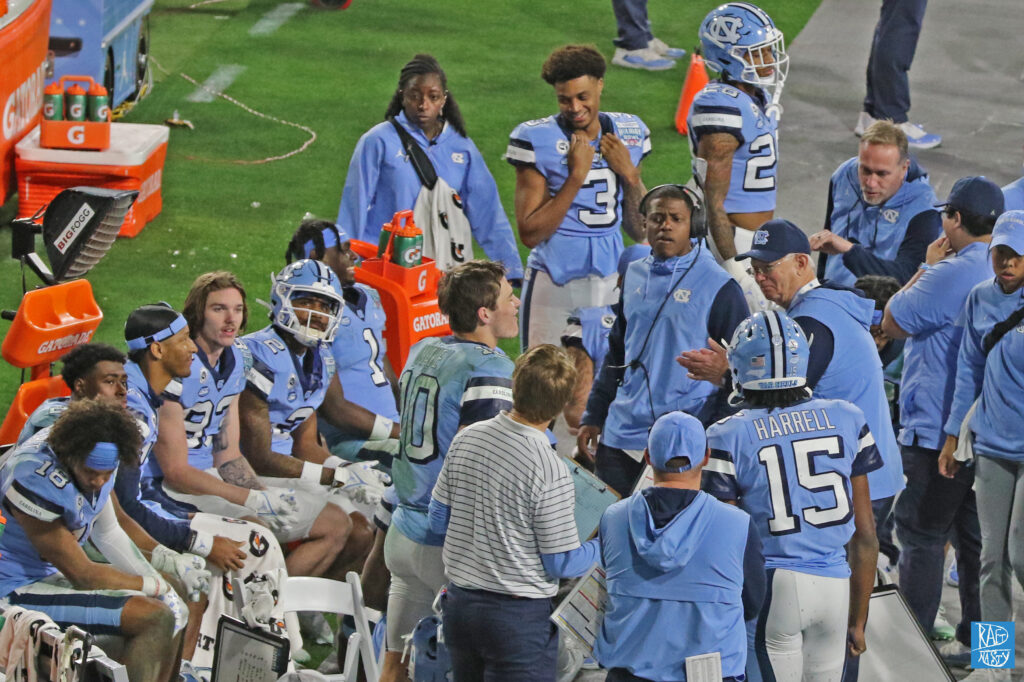 North Carolina's Drake Maye talks on the sideline with coaches during the game